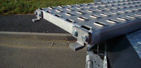 Deux rampes aluminium 1250x500 mm adaptables en bout du plateau pour permettre le débordement des roues du véhicule transporté