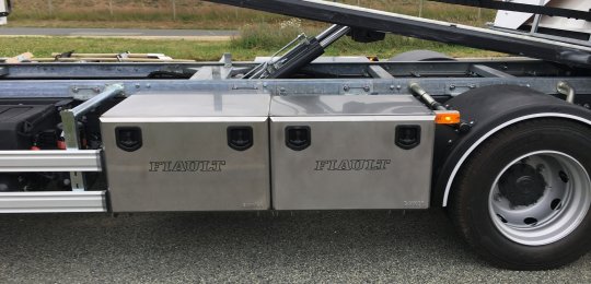 A closed stainless steel storage box with a sliding drawers for two wheel dollies type "GO-JACK 5000" (without dollies)